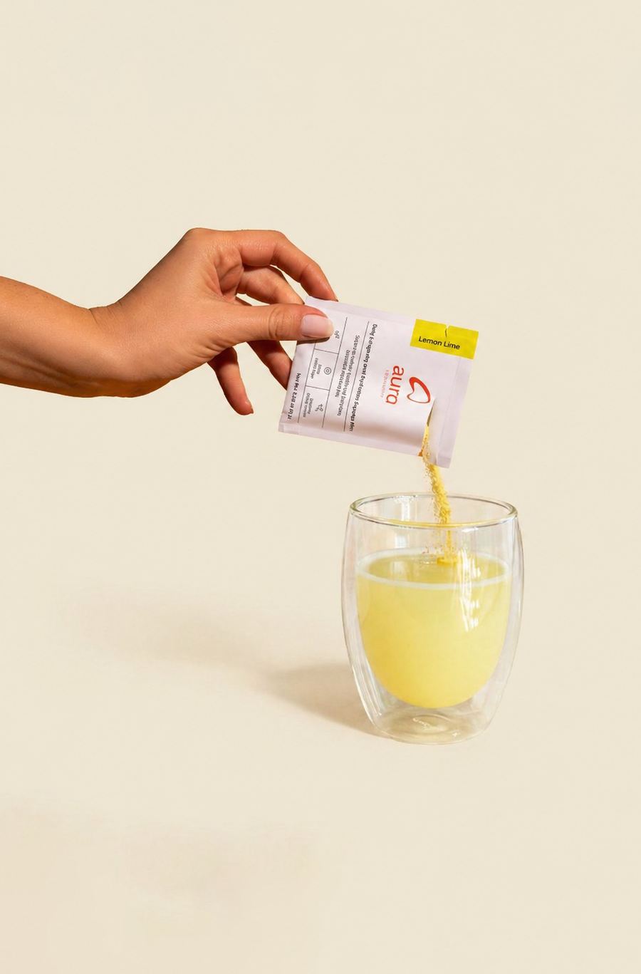 Aura Lemon Lime being poured into a glass of water